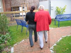 campania assistenza anziani operatrice che passeggia con anziano